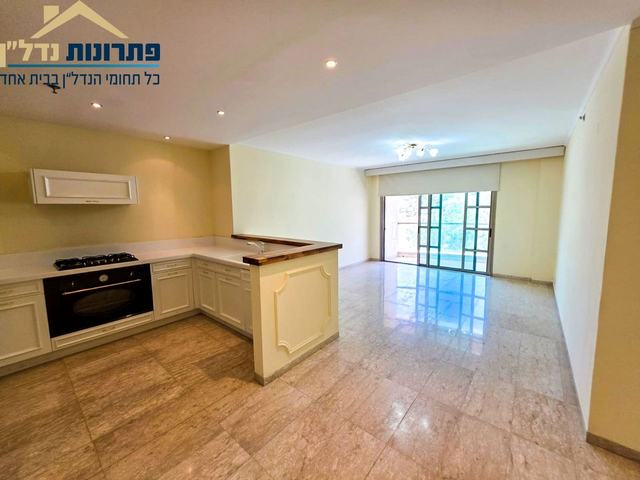 סלון ומטבח פתוח עם יציאה למרפסת – דירת 3 חדרים ברחוב יפה נוף, מרכז הכרמל, חיפה